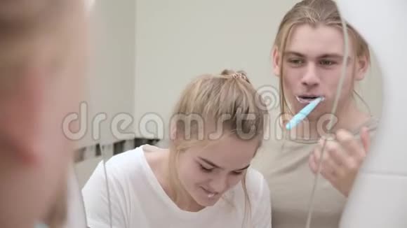 年轻夫妇在洗澡时一起刷牙照镜子特写视频的预览图