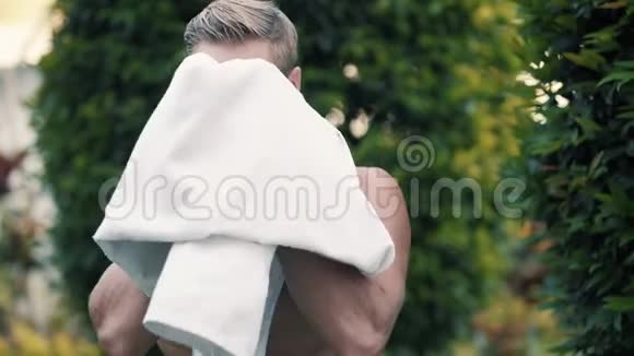 游泳后性感男士用毛巾擦拭脸部和身体视频的预览图