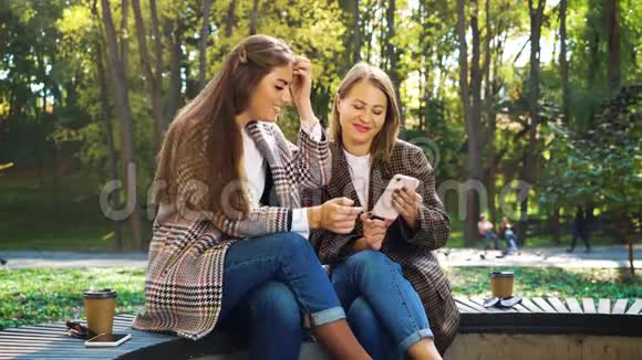 时尚女孩在公园里使用智能手机在社交媒体上观看照片视频的预览图