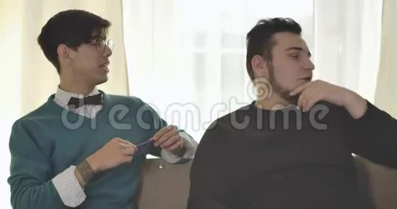 两个白人大学生坐在沙发上聊天男朋友在家讨论作业情报视频的预览图