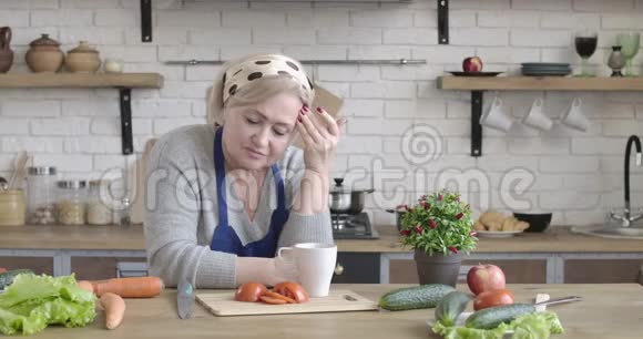 孤独的白种人退休者的肖像看着远离现代厨房在家里沮丧的中年妇女视频的预览图