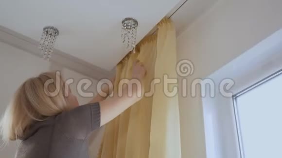 在打扫房子的时候一个女人把薄纱挂在窗户上视频的预览图