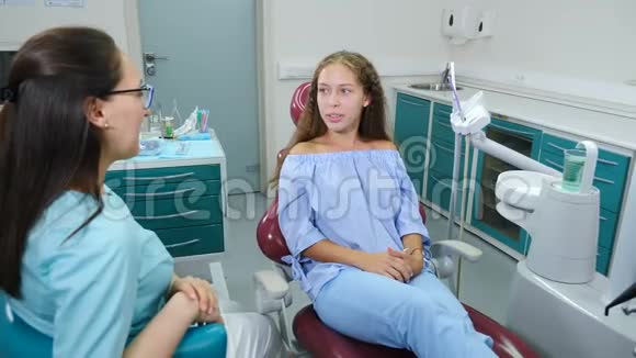 在牙科诊所正畸的概念关于正畸医生会诊在牙科医生的牙齿上有牙痕的漂亮女孩视频的预览图