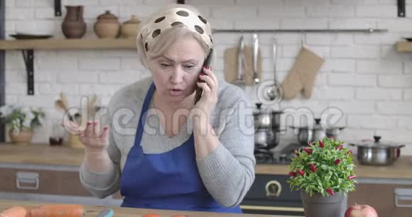 穿着棕色眼睛的白人女人在电话里聊天挂了电话愤怒的女性退休人员支出画像视频的预览图