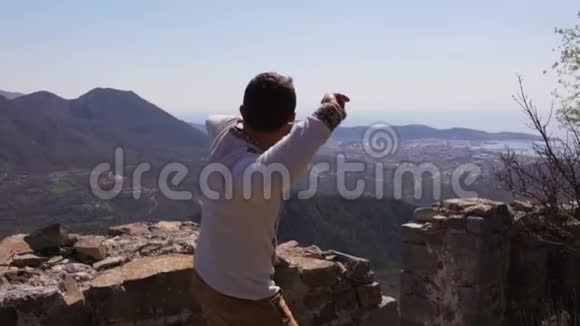 英俊的男人正在向悬崖扔石头夏季视频的预览图