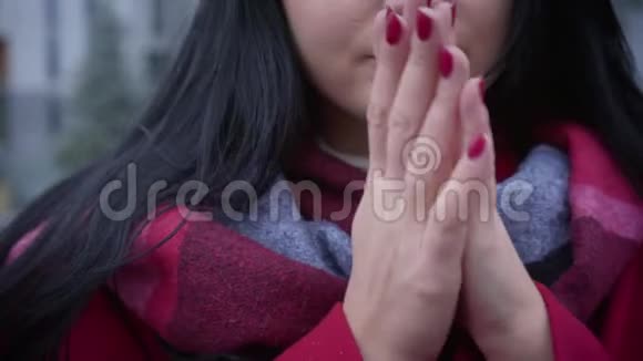 一个面目全非的年轻白种人女人的特写揉着手吹着手热身一头黑发的女士视频的预览图