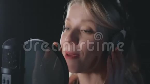 女歌手声乐家在录音室的麦克风录音歌曲中唱歌视频的预览图