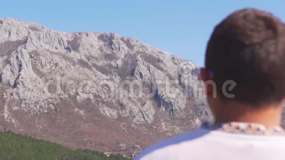 年轻人抬头看着山的地平线视频的预览图