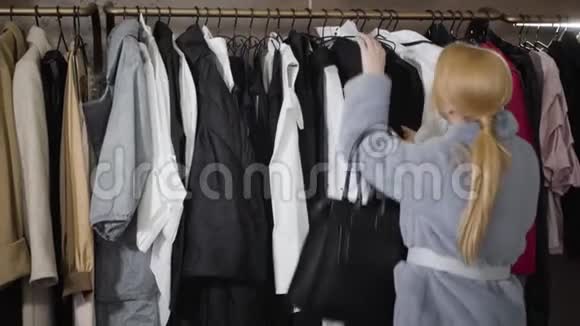 时尚的年轻白种人女人在商店里谈论着衣架上的黑色连衣裙时尚精品店的时尚女富豪购物视频的预览图