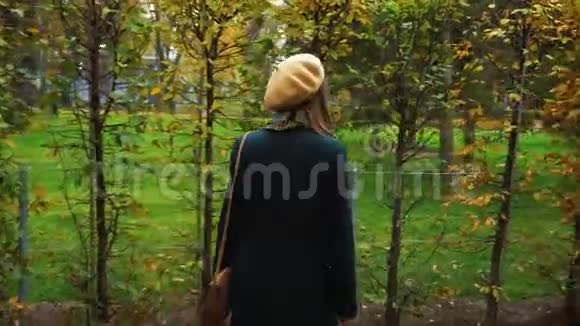 秋天穿着优雅服装在花园迷宫里散步的快乐女孩视频的预览图
