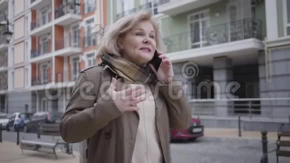 成熟优雅的白种人女人在城市街道上散步和在电话中交谈的肖像压力很大的老太太视频的预览图