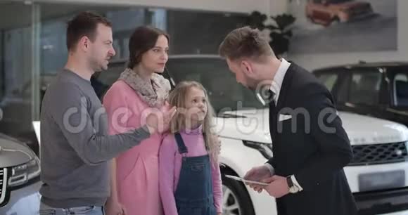 成功的白人商人握手汽车经销商的手和亲吻妻子的脸颊充满欢乐的家庭视频的预览图