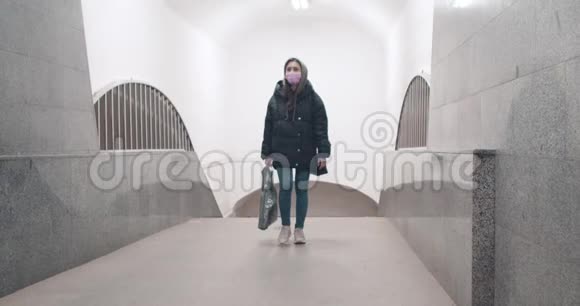 戴防护面具的年轻女孩在空楼里散步视频的预览图