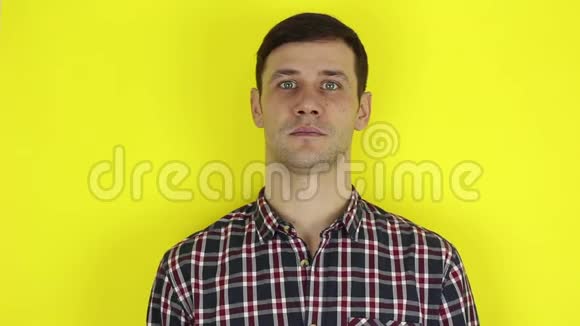 穿格子衬衫的帅哥露出食指点点头黄色背景上的肖像视频的预览图