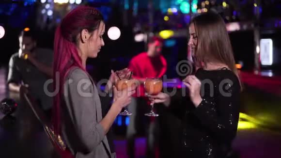 两个年轻的白种人女人在酒吧柜台跳舞就像英俊的中东男人带着饮料来积极的人视频的预览图