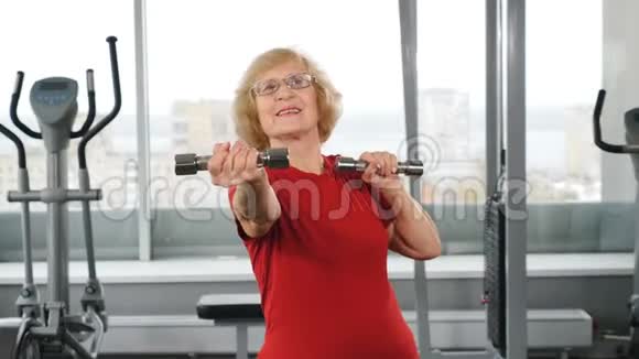 活跃的老年退休妇女带着杠铃在健身房主动快乐的晚年理念积极的退休人员视频的预览图