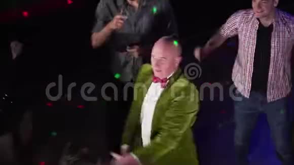 穿绿色夹克的老白种人活跃滑稽舞蹈的俯视图积极的老人在夜总会休息快乐视频的预览图