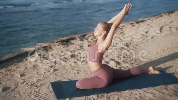 女人做瑜伽运动早上伸展看海洋慢动作视频的预览图