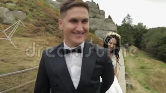 新郎新娘在山上散步新婚夫妇新婚夫妇视频的预览图