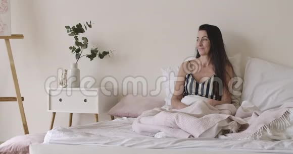 布鲁内特高加索女人躺着像一个英俊的丈夫端着茶牛角面包和鲜花的床盘亲吻妻子视频的预览图