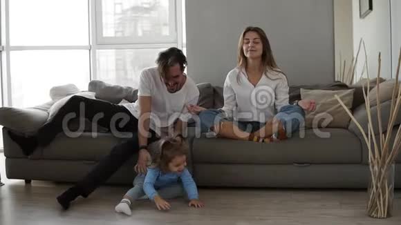 有意识的白种人母亲坐在沙发上沉思而活跃的精力充沛的孩子女儿则在玩耍视频的预览图