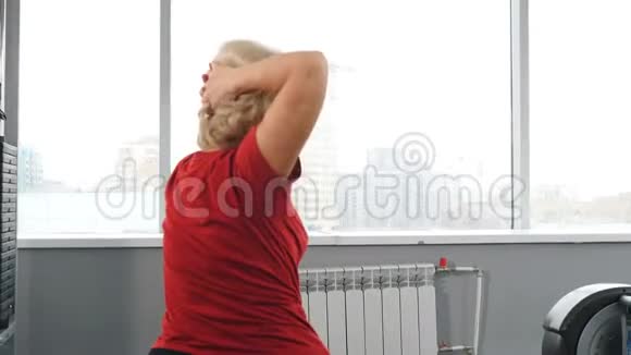 高级女子体操训练退休妇女坐在健身房健身球锻炼的后视图主动概念视频的预览图