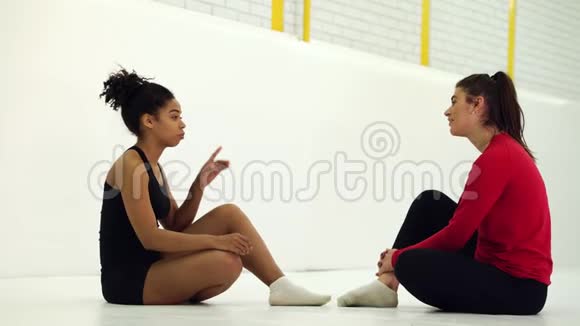 很多黑人女孩坐在健身房的垫子上聊天视频的预览图