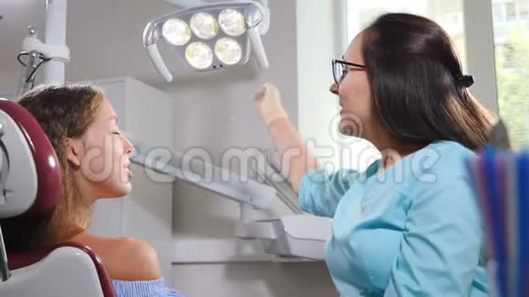 女性年轻病人牙科椅的俯视图医生在治疗前安排灯灯特写镜头牙医诊所视频的预览图