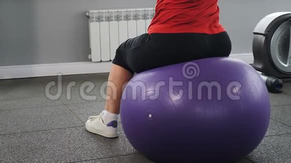退休妇女坐在健身球上健身房锻炼的背面积极和健康的养老金领取者的概念长者视频的预览图