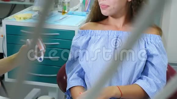 儿童牙科牙齿保护概念漂亮的16岁女孩手里拿着牙齿模型微笑开朗的病人视频的预览图