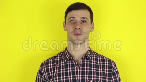 穿格子衬衫的帅哥露出食指点点头黄色背景上的肖像视频的预览图