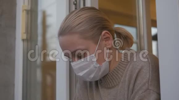 一个戴着医用面具的女人望着窗外视频的预览图