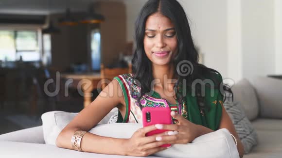 印度妇女在家里使用智能手机视频的预览图