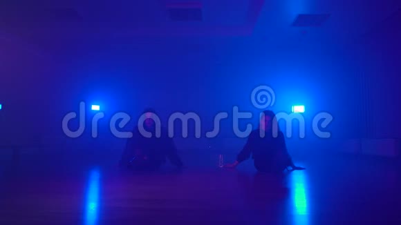 性感的女孩在黑暗的工作室里的双人舞里面有雾和霓虹灯视频的预览图
