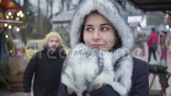 戴着黑白帽子和手套的白种人女人站在户外男人从户外走来的画像视频的预览图