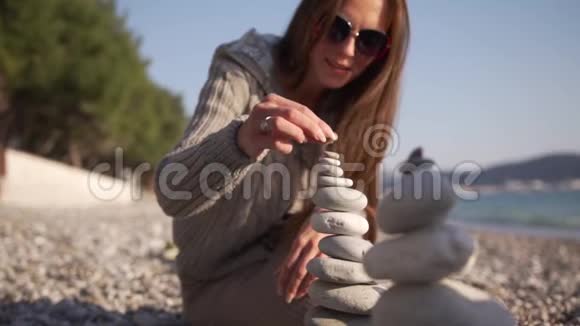 特写女郎用手在海岸上折叠一座金字塔视频的预览图
