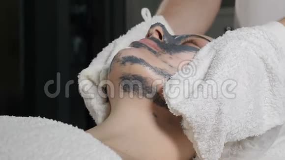 剥皮美和身体护肤美容师从女性客户脸上取出面部化妆面具特写镜头视频的预览图