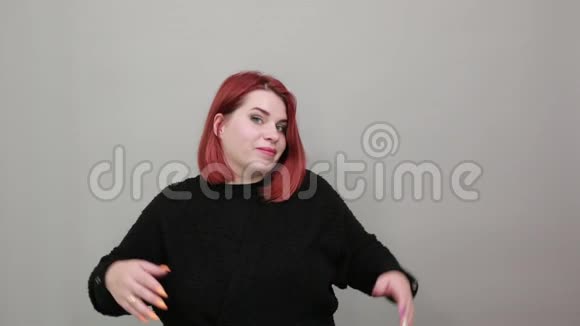 年轻的红头发胖女人穿黑色毛衣女人怀疑决定张开双臂视频的预览图