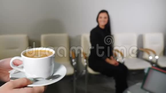 女接待员把咖啡带给办公室里的女客户斯坦迪卡姆秘书拿着一杯视频的预览图