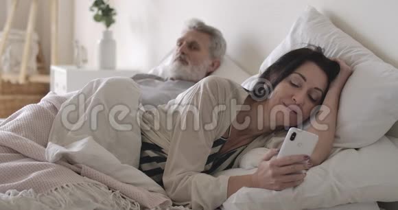 嫉妒的高加索人在智能手机屏幕上和妻子聊天视频的预览图