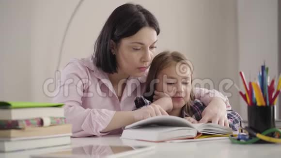 聪明的白种人女孩为妈妈读书的肖像可爱的学童和母亲一起做作业家长帮助视频的预览图