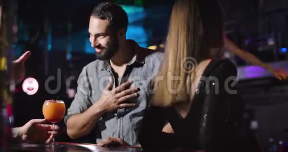 性格开朗的中东年轻人在夜总会喝鸡尾酒和酒保交谈快乐的大胡子帅哥视频的预览图