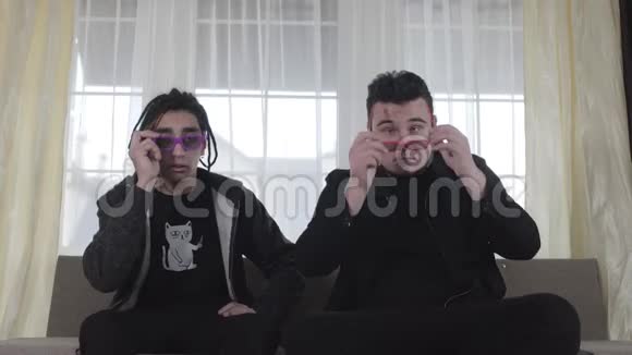 年轻的白种人男子戴上3D护目镜进入不同的方向两个快乐的男性朋友做鬼脸视频的预览图