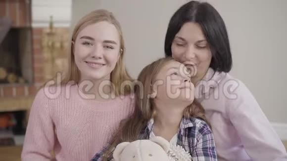可爱的白种人黑发女孩与母亲和姐姐摆姿势的肖像快乐的家庭看着相机视频的预览图