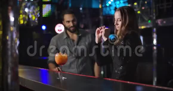 自信的中东青年男子来到迷人的白种人女孩跳舞旁边的酒吧柜台帅哥在调情视频的预览图