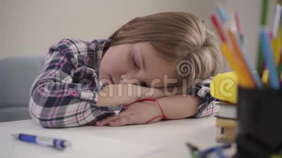 疲惫的白种人女学生睡在桌子上的特写肖像精疲力竭的孩子正在睡觉视频的预览图