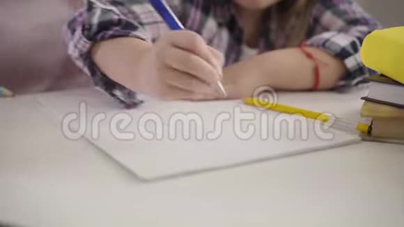 作业本中幼儿手画线条的特写坐在桌子旁做作业的女学生视频的预览图
