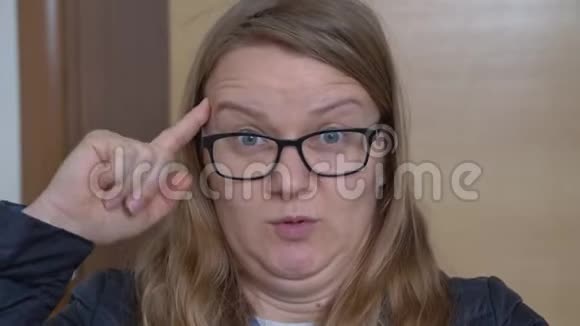 戴眼镜的女性用食指靠近头部做圆周运动视频的预览图