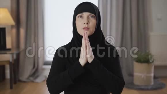 镜头慢慢地靠近年轻美丽的穆斯林女子手牵手祈祷成人女士视频的预览图