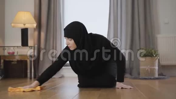 美丽的穆斯林妇女戴头巾清洁地板和用手擦前额的肖像东部家庭主妇视频的预览图